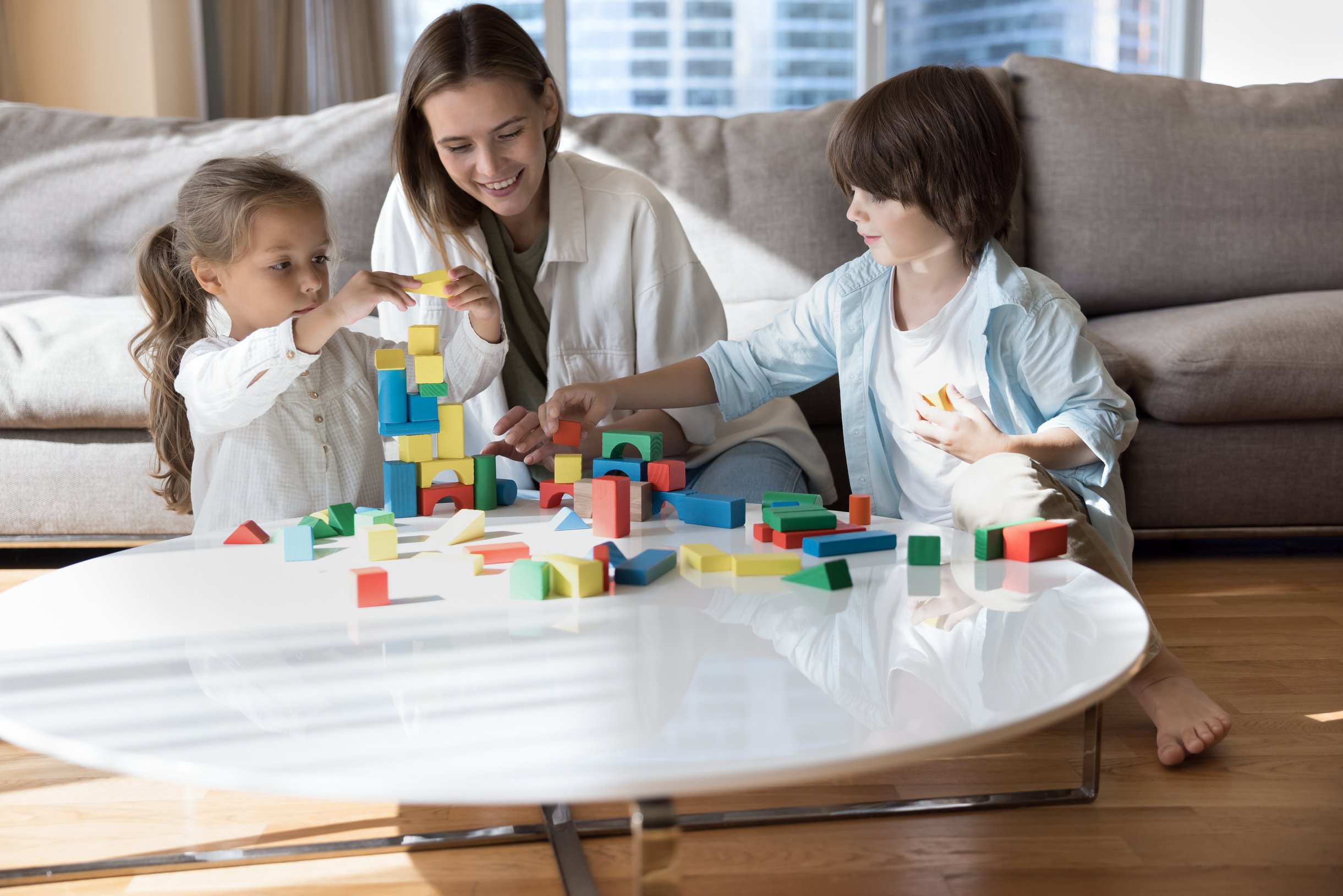 Cheerful young daycare teacher, nanny playing smart game